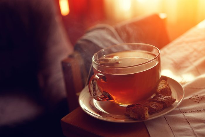 glass mug of tea on saucer