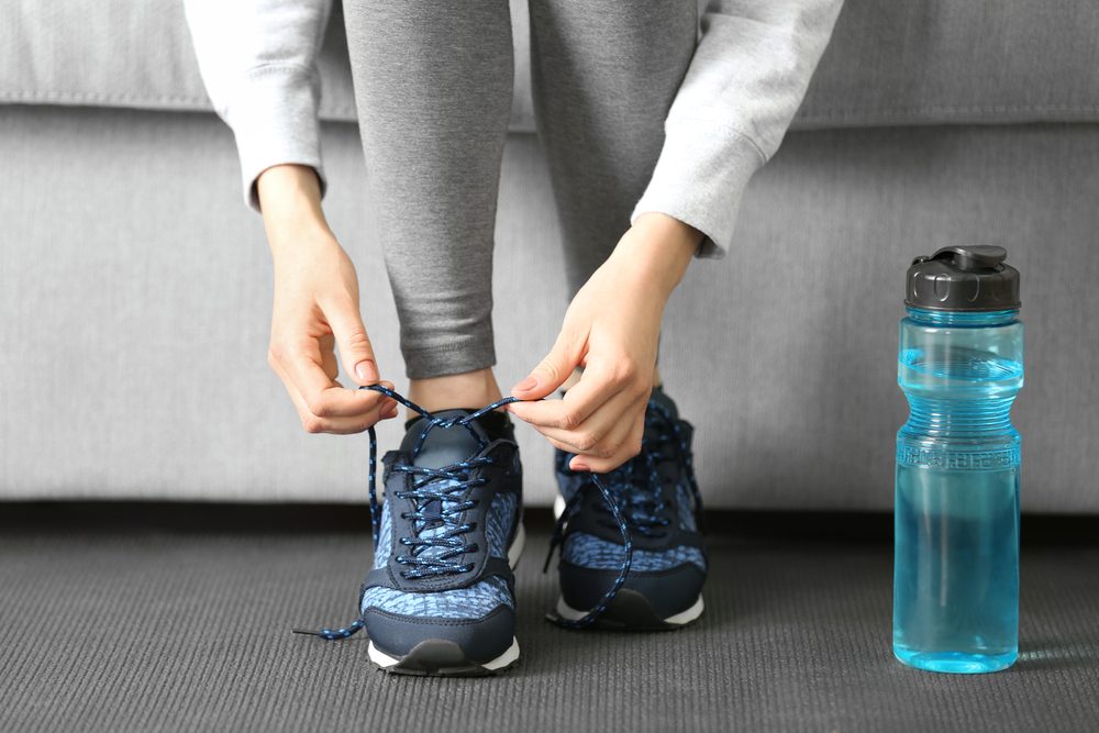 Woman tying up running shoe