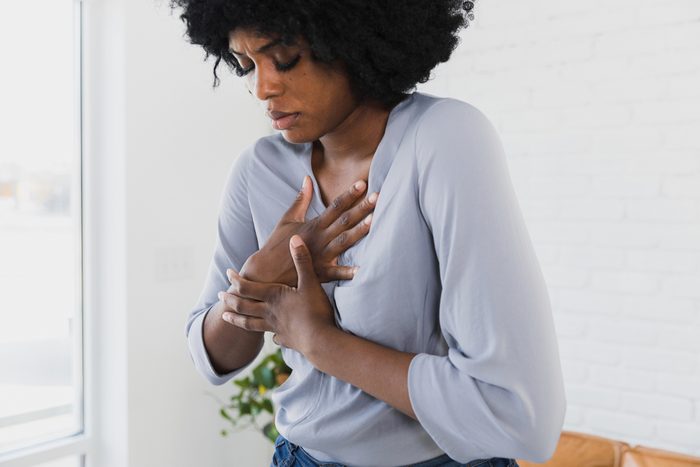 Mid adult woman holds chest
