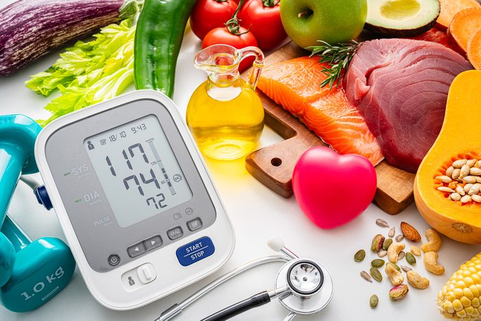Close up of blood pressure gauge and food products recommended for hypertension control and lower blood pressure