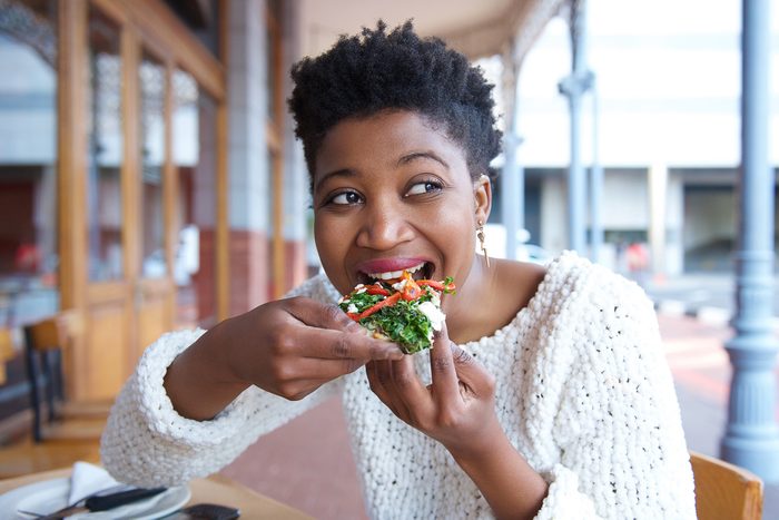 woman eating pizza at restaurant