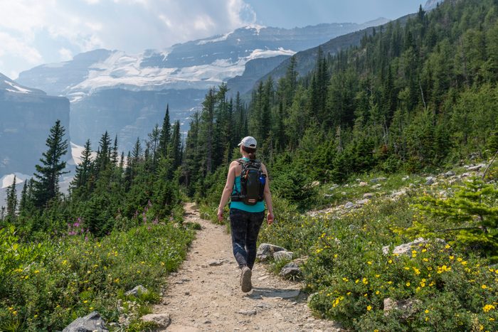 Woman hikes along trail, in Banff National Park