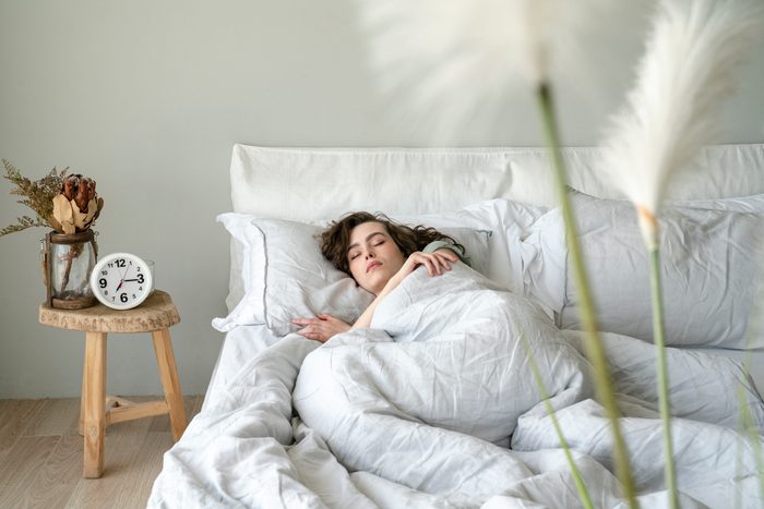 Young woman sleeping in bed in bedroom