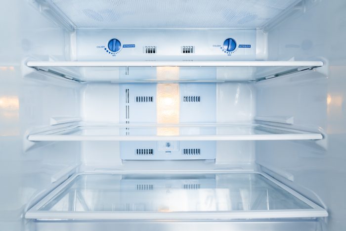 Inside of a white empty refrigerator with the interior light on