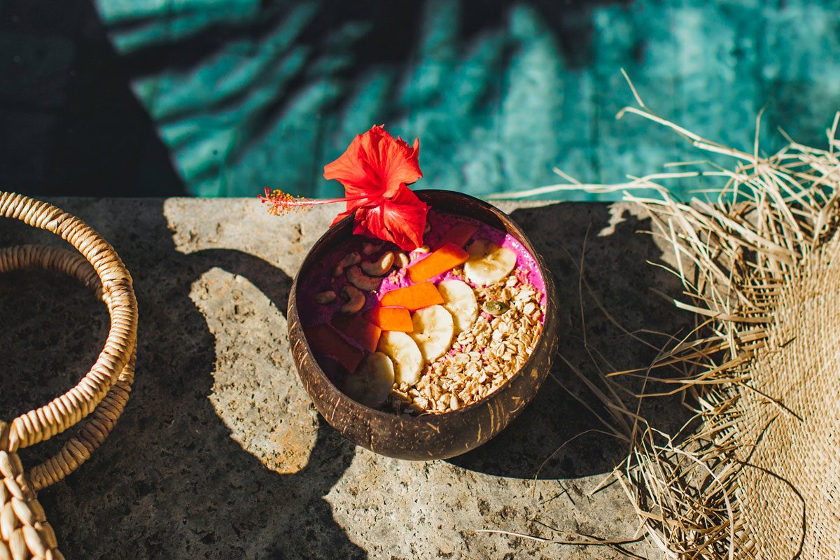 fruit smoothie bowl next to pool